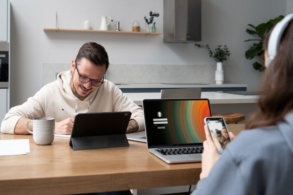 man and woman working together from home at the desk