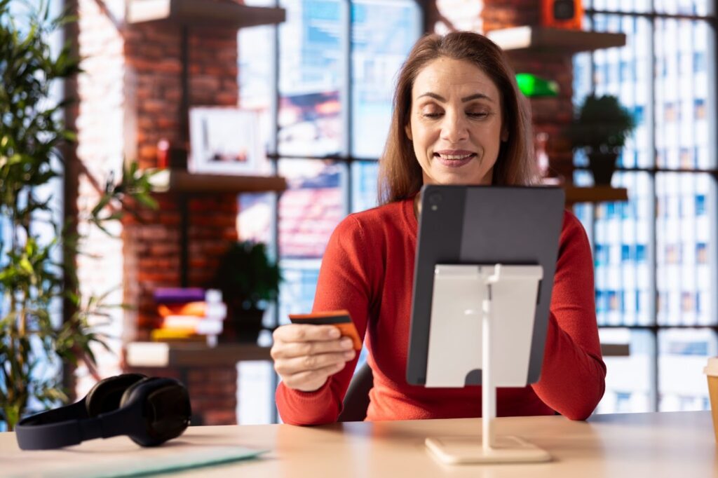 A Caucasian adult at home pays for an online order on their tablet