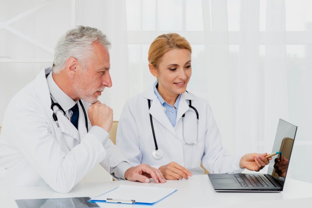 doctors looking at laptop while sitting